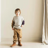 Lucky Bird Sweater van Jenest voor jongens, met contrasterende mouwen in plum en hazelnut en een zwaluw-patch op de rug. | Verkrijgbaar bij Little Fashion Addict